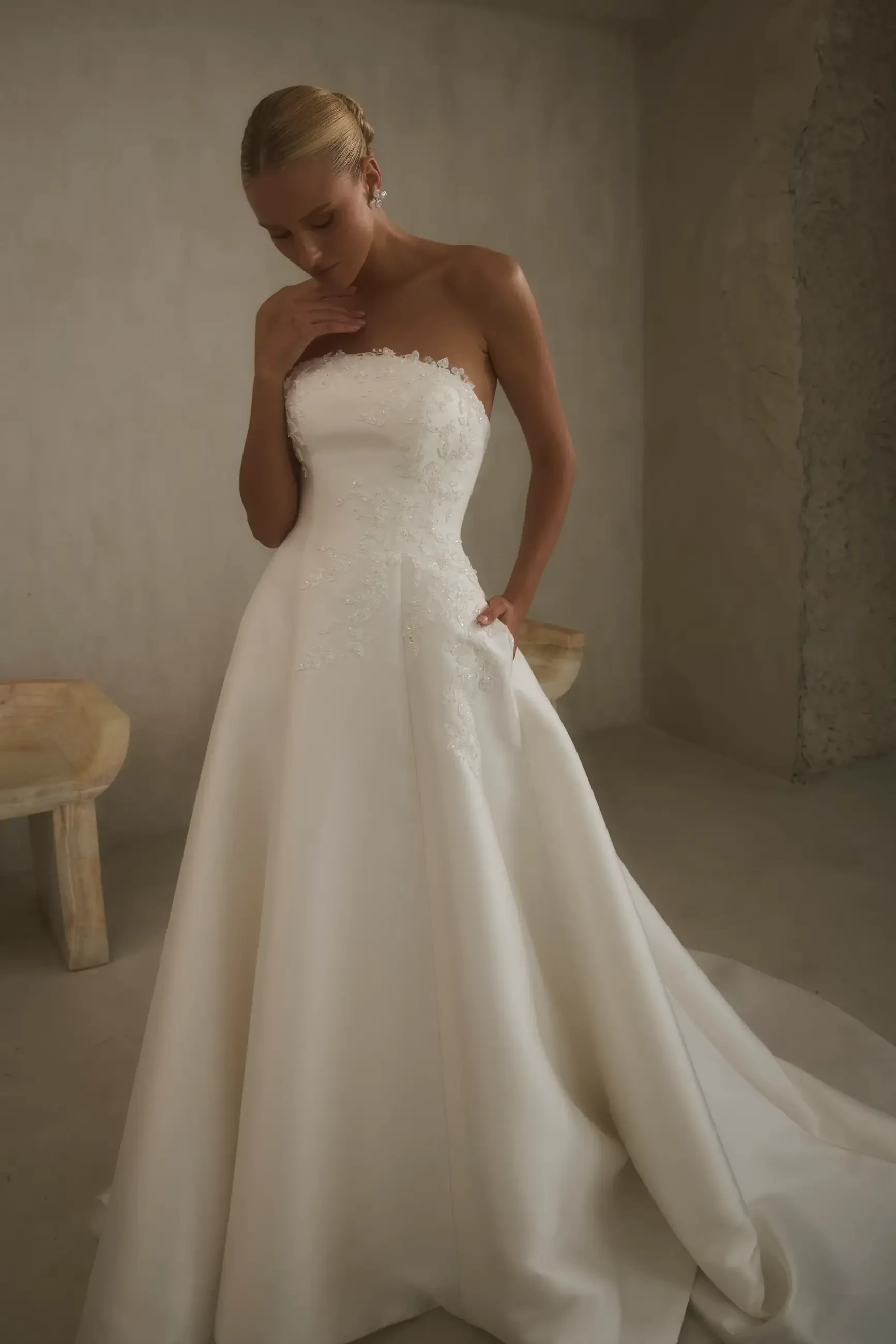 model is wearing a strapless ball gown wedding dress