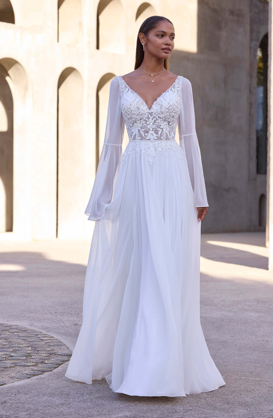 model is wearing a long sleeve a-line wedding dress