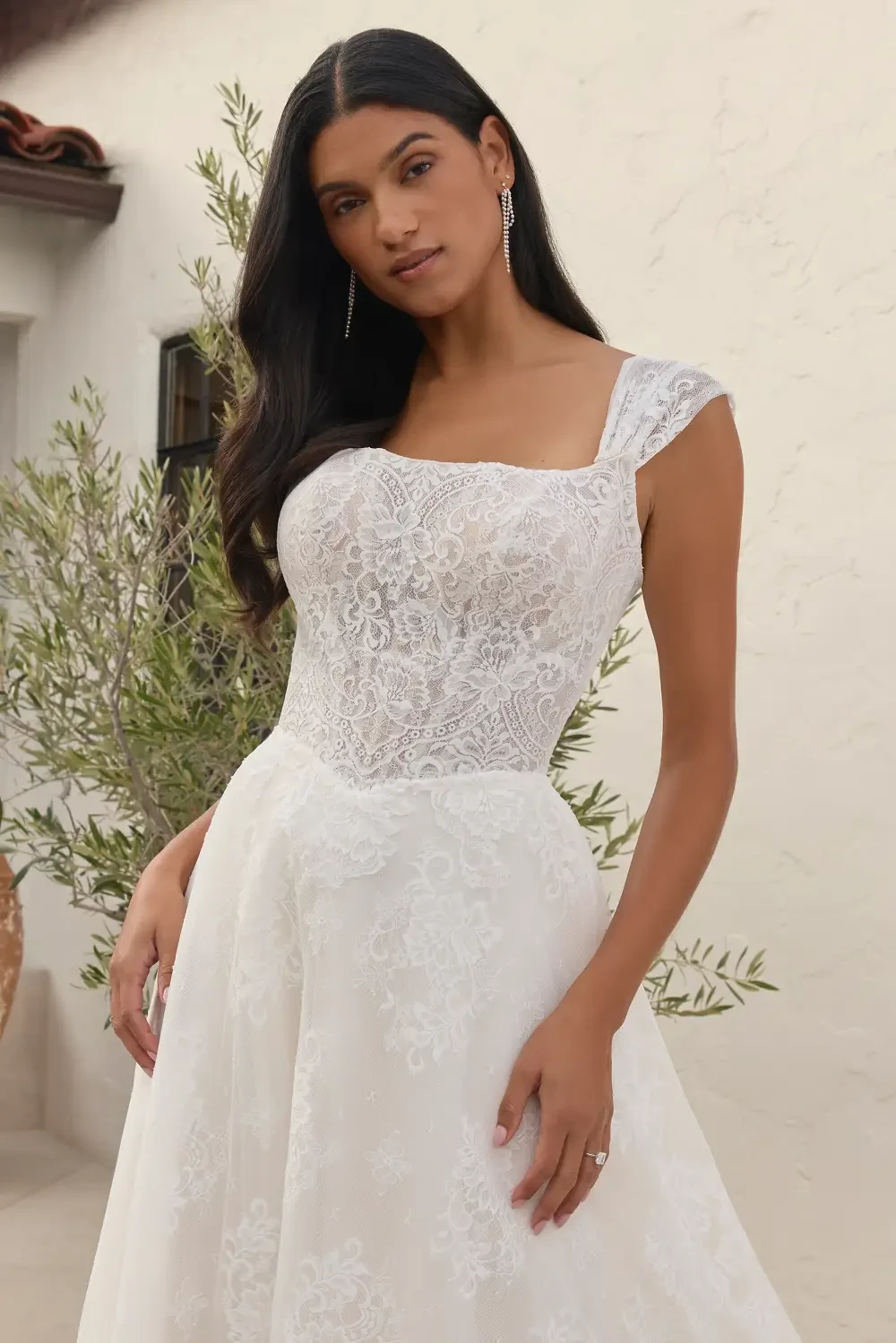 model is wearing a short sleeve bridal gown
