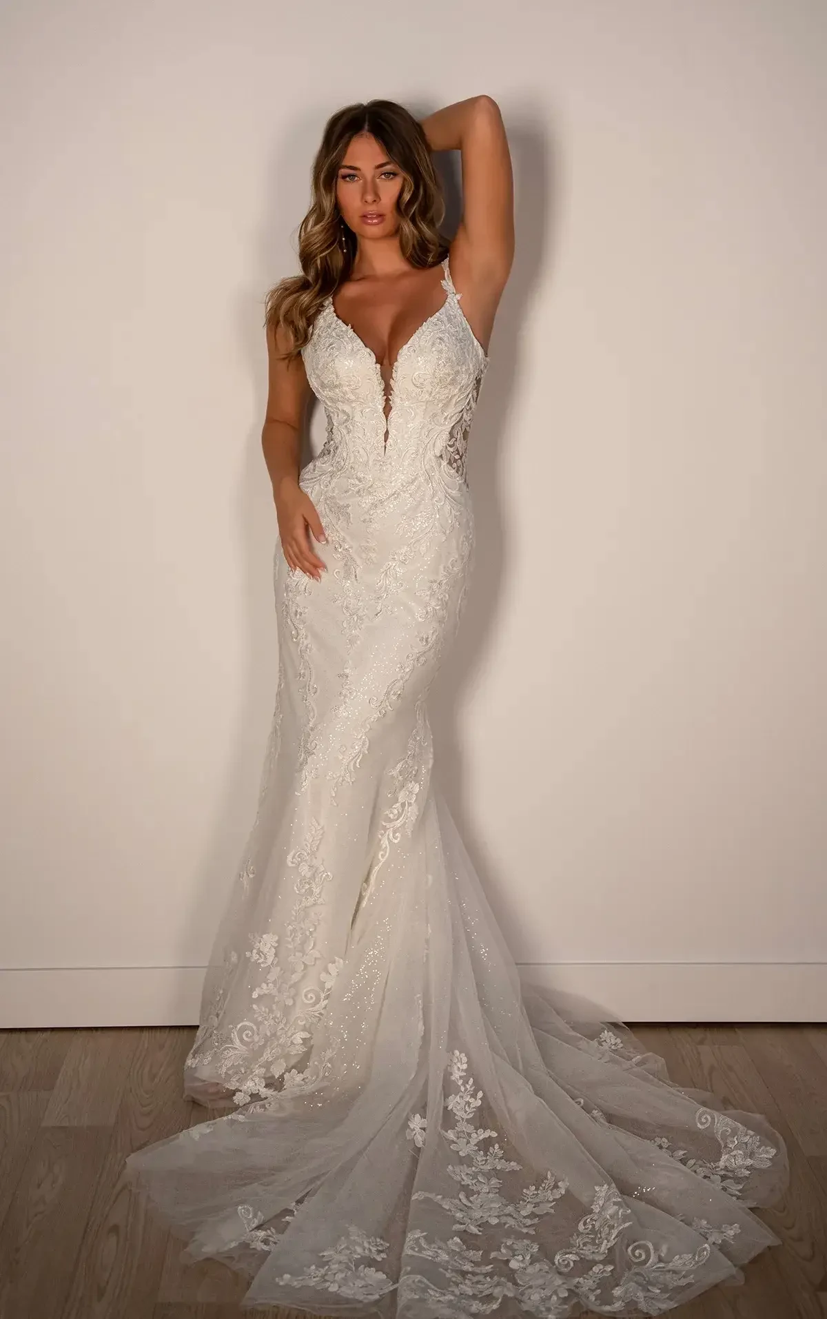 model is wearing a sleeveless fit and flare wedding gown