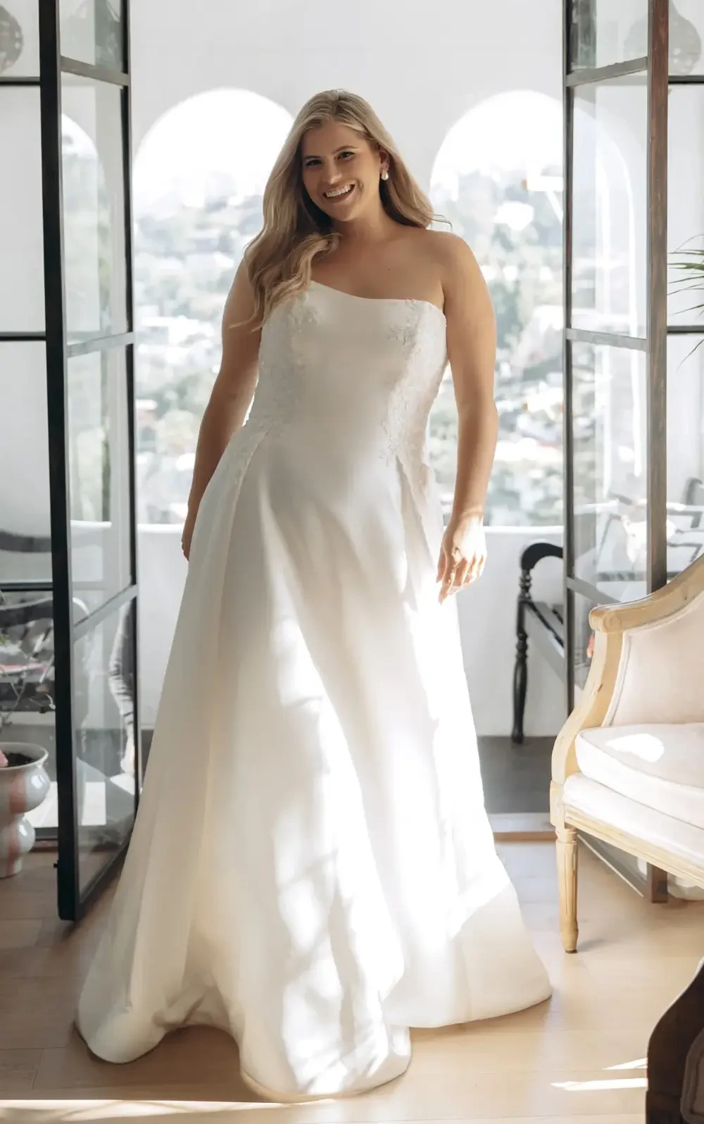 model is wearing a plus size strapless a-line bridal gown