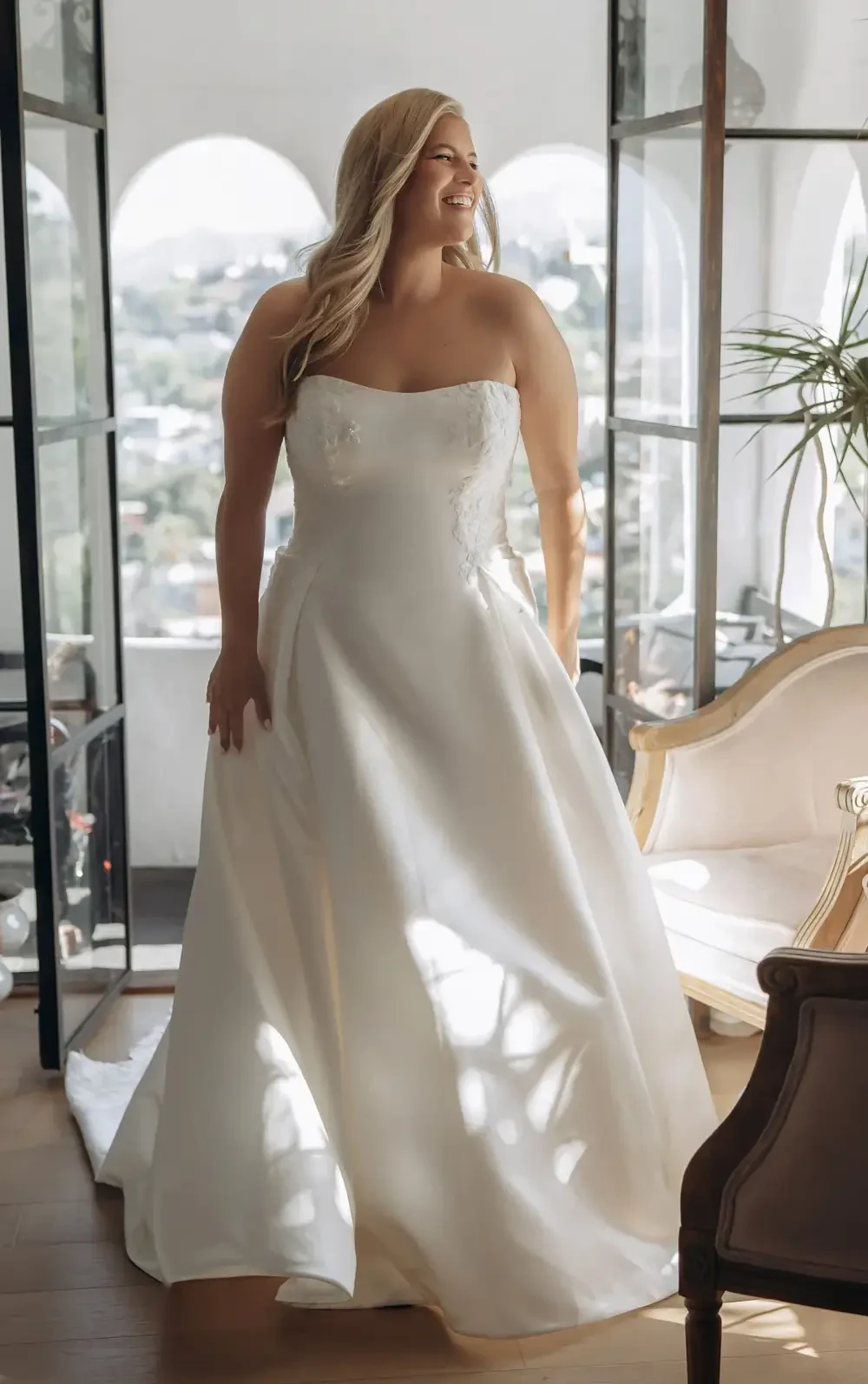 model is wearing a plus size strapless a-line bridal gown