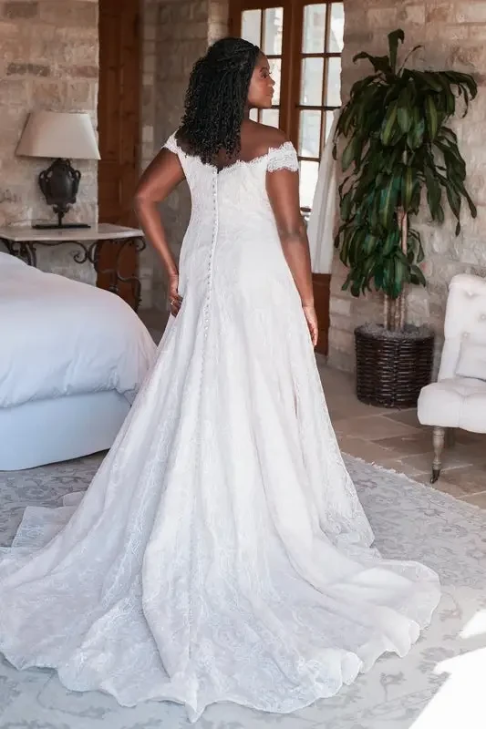 model is wearing a plus size off the shoulder a-line bridal gown